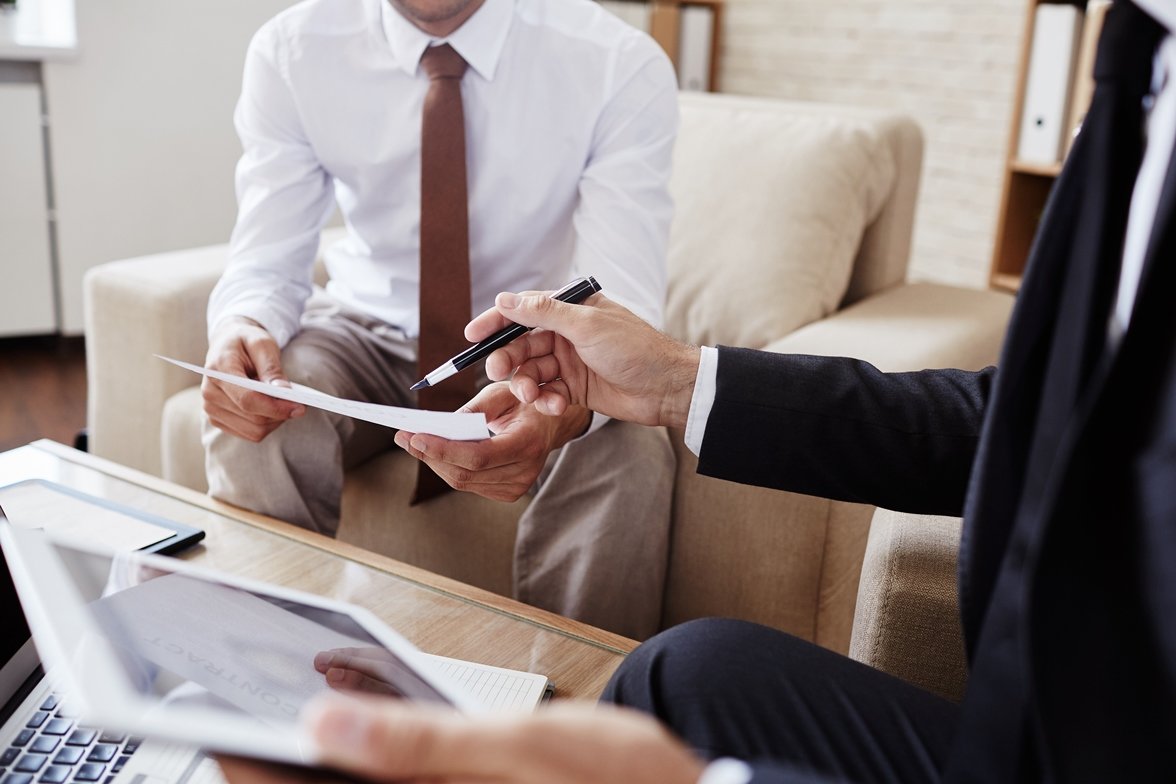 Businessman pointing at document held by his colleague